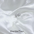Silver heart-shaped earrings on white satin fabric with 'Precious Lifetime Memories by Annabel' branding.