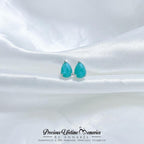 Teal teardrop earrings on a white satin background with 'Precious Lifetime Memories by Annabel' branding.