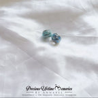 Blue gemstone earrings on a white fabric background with 'Precious Lifetime Memories by Annabel' branding.