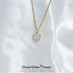 Gold necklace with a heart-shaped pendant on a white fabric background, 母乳项链