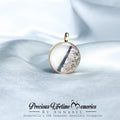 Gold pendant with a circular design on a light fabric background, featuring 'Precious Lifetime Memories by Annabel'.