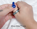Close-up of hands holding a ring with 'Precious Lifetime Memories by Annabel' branding.