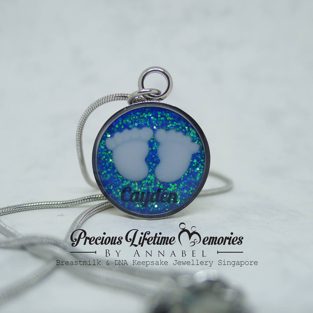 Necklace with a round pendant featuring blue and green opal-like material on a white background.