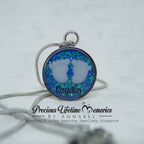 Necklace with a round pendant featuring blue and green opal-like material on a white background.