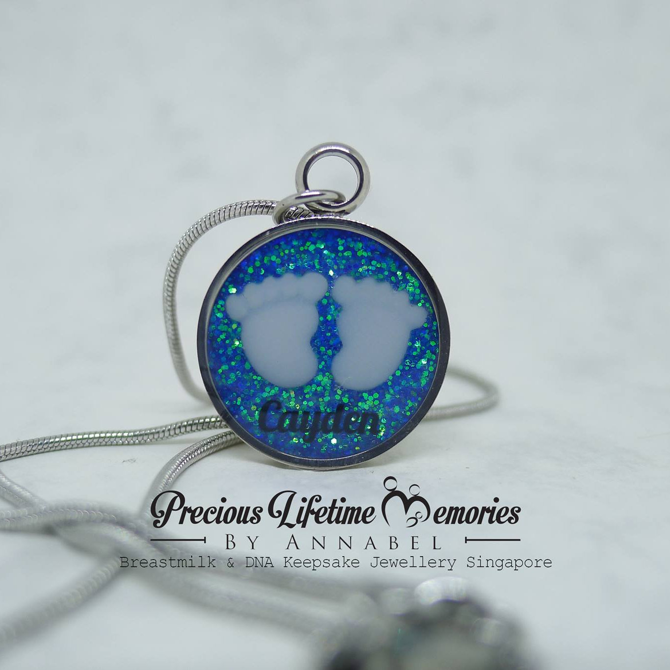 Necklace with a round pendant featuring blue and green opal-like material on a white background.