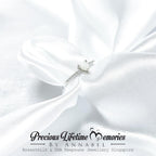 Silver earring on white fabric with 'Precious Lifetime Memories keepsake by Annabel' branding.