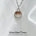 Necklace with a round pendant on a white satin background, featuring the brand 'Precious Lifetime Memories by Annabel'.