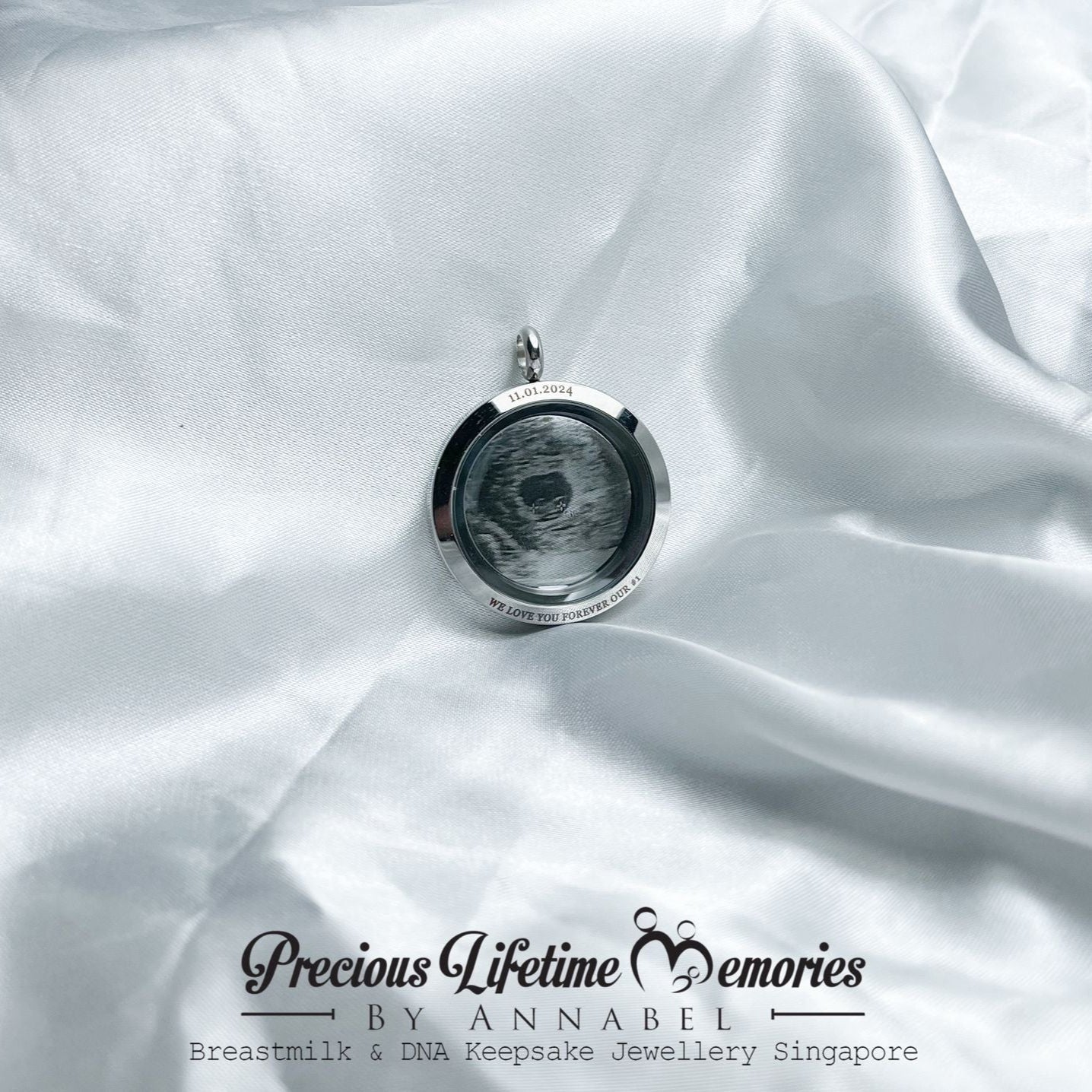 Necklace with a locket on white fabric, featuring 'Precious Lifetime Memories by Annabel'.