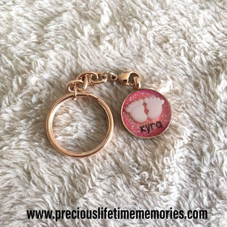 Rose gold keychain with a pink charm on a white fluffy surface