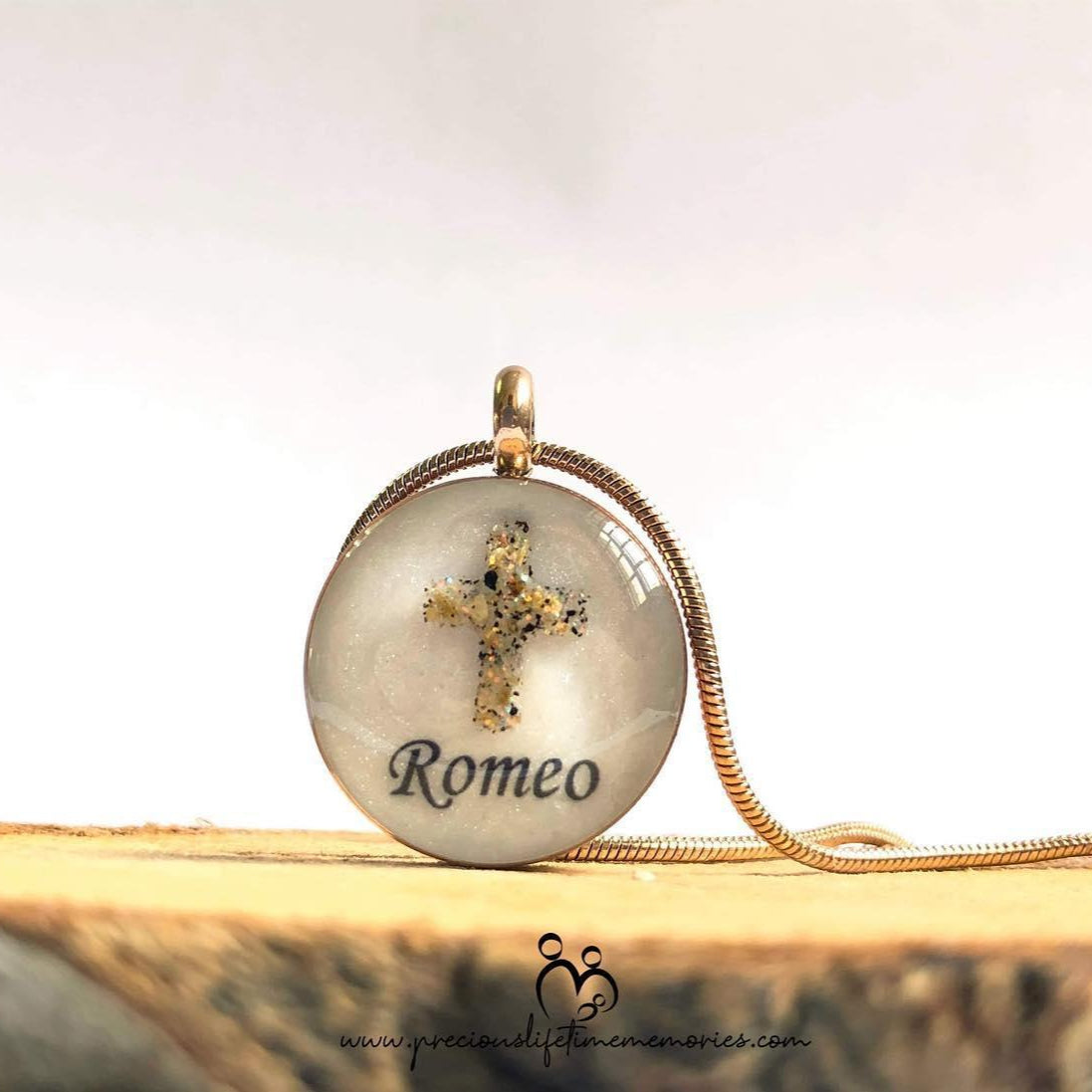 Necklace with a pendant engraved with 'Romeo' on a wooden surface.
