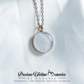 Necklace with a round pendant on a white fabric background, featuring the brand 'Precious Lifetime Memories by Annabel'.
