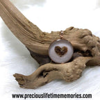 Necklace with a heart-shaped pendant on a piece of driftwood, featuring the brand 'preciouslifetimememories.com'.