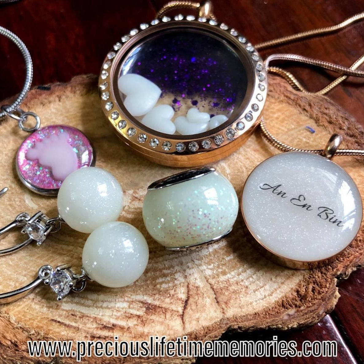 Jewelry set including necklaces and earrings on a wooden surface with 'An En Bin' engraved.