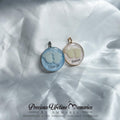 Two round pendants on a white fabric background with 'Precious Lifetime Memories by Annabel' branding.