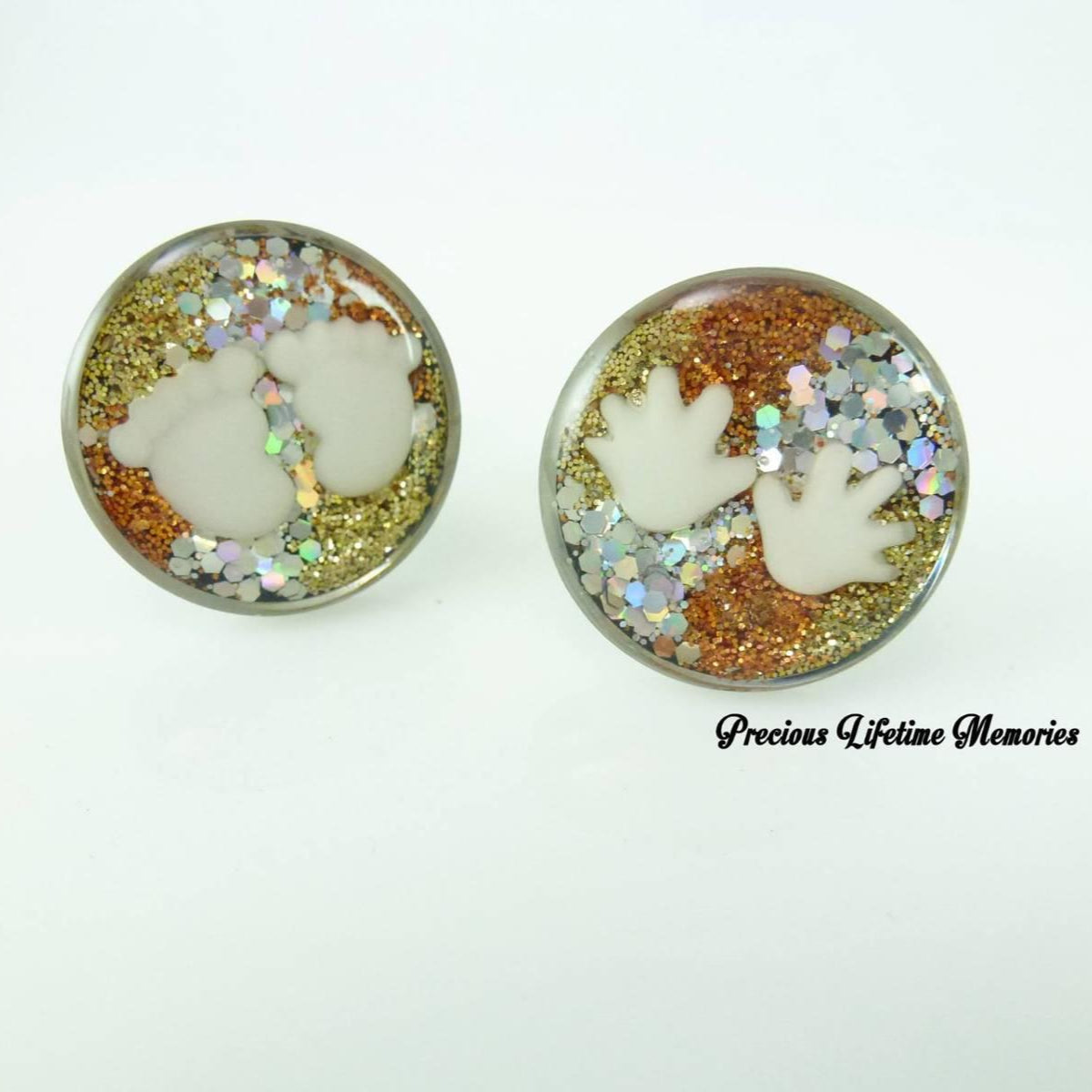 Pair of earrings with paw prints and glitter on a white background