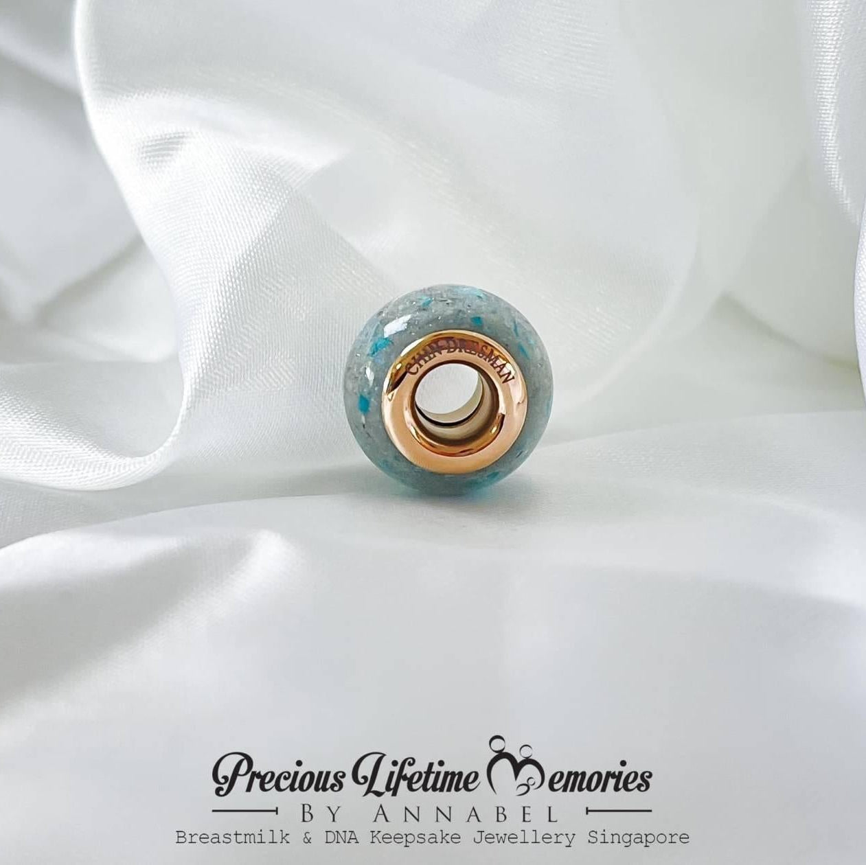Jewelry charm engraving on a white fabric background with 'Precious Lifetime Memories by Annabel' branding.