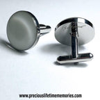 Silver cufflinks on a light gray background with a website address.