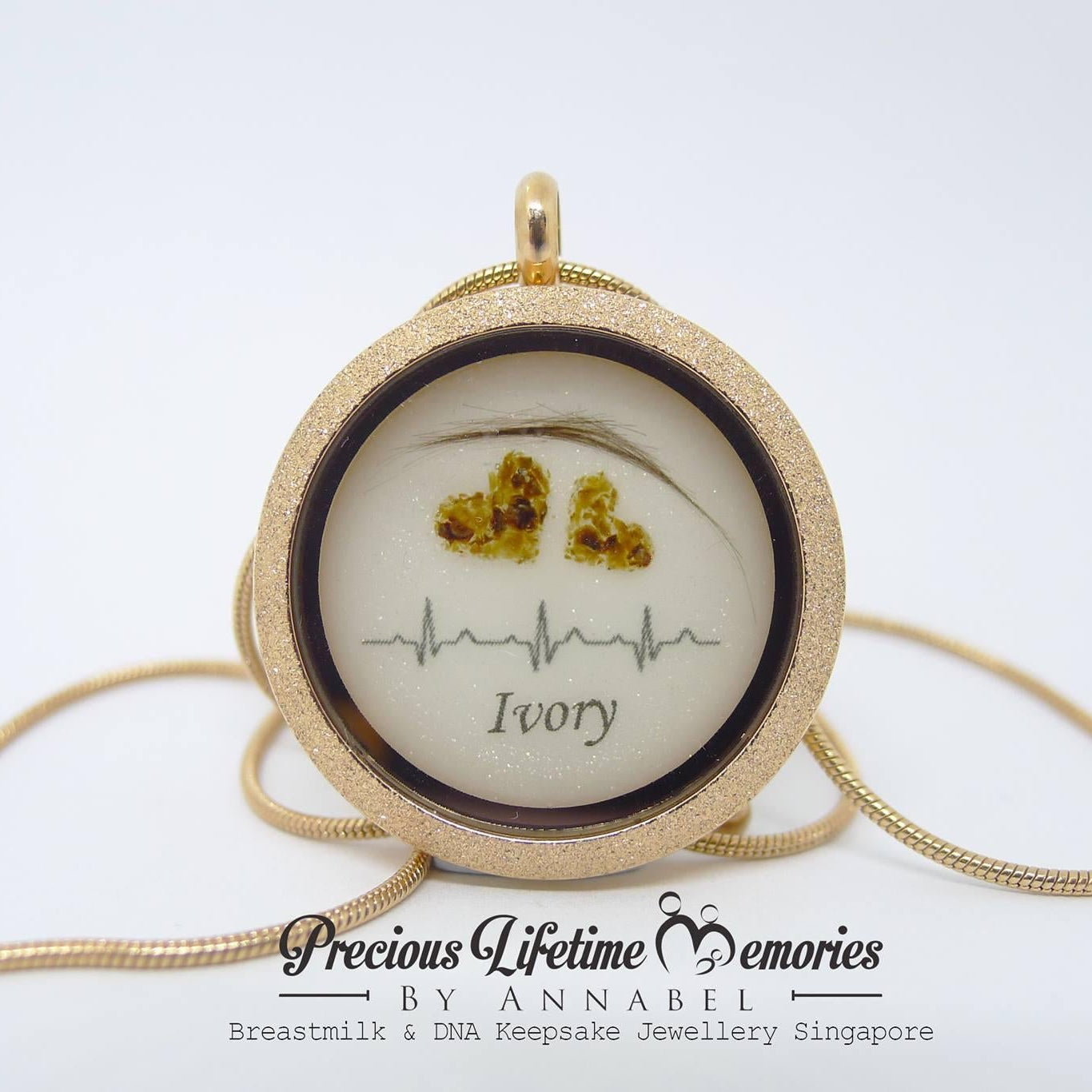 Gold necklace with a heart design and 'Ivory' text on a white background