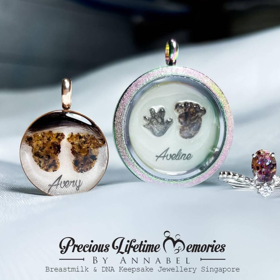 Jewelry set with a pendant, ring, and small round item on a white surface, featuring 'Precious Lifetime Memories by Annabel'.