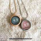 Two necklaces with round pendants on a textured white surface, featuring the brand 'precious lifetime memories'.