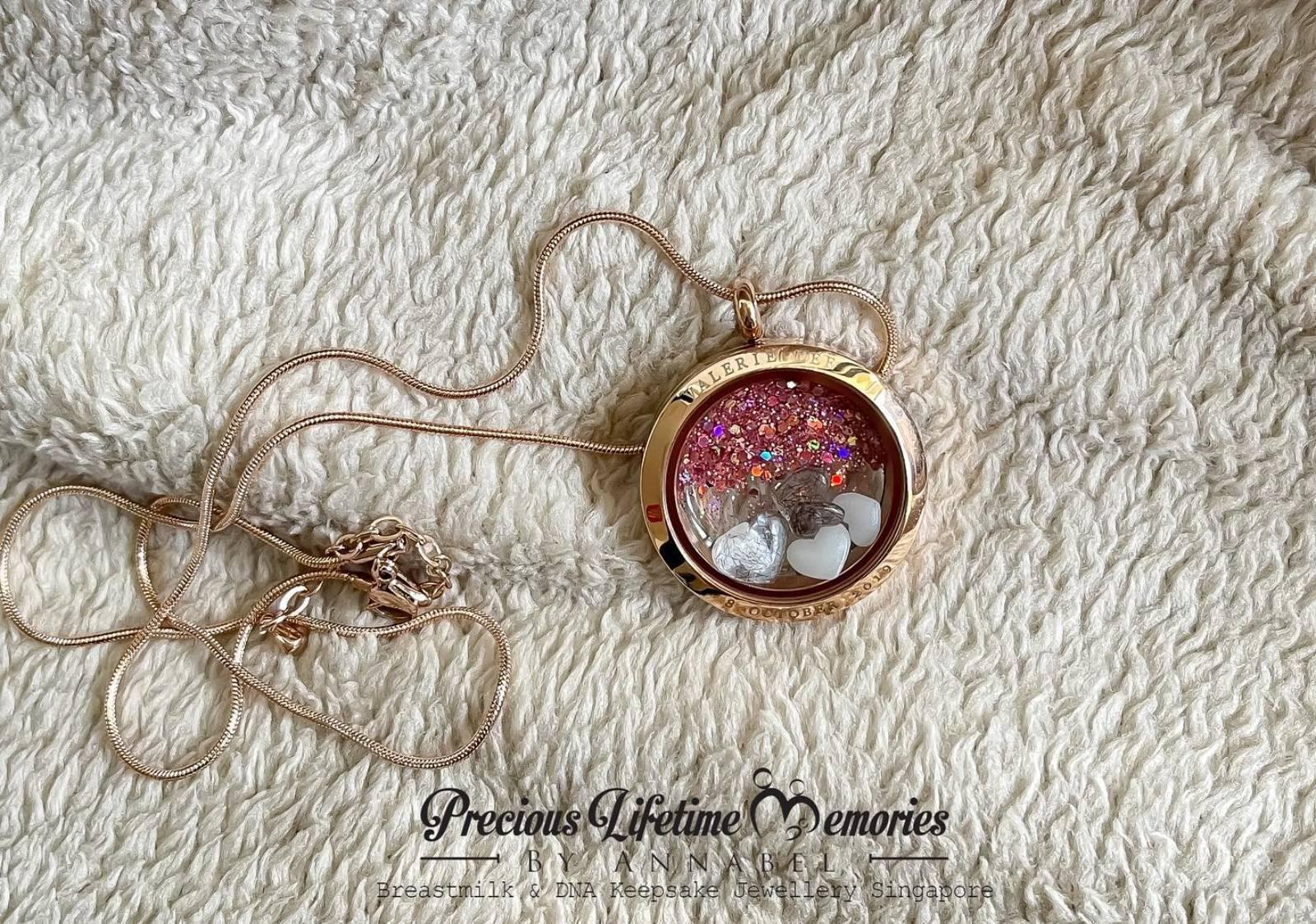 Rose gold locket with decorative elements on a textured white surface, featuring 'Precious Lifetime Memories' text.