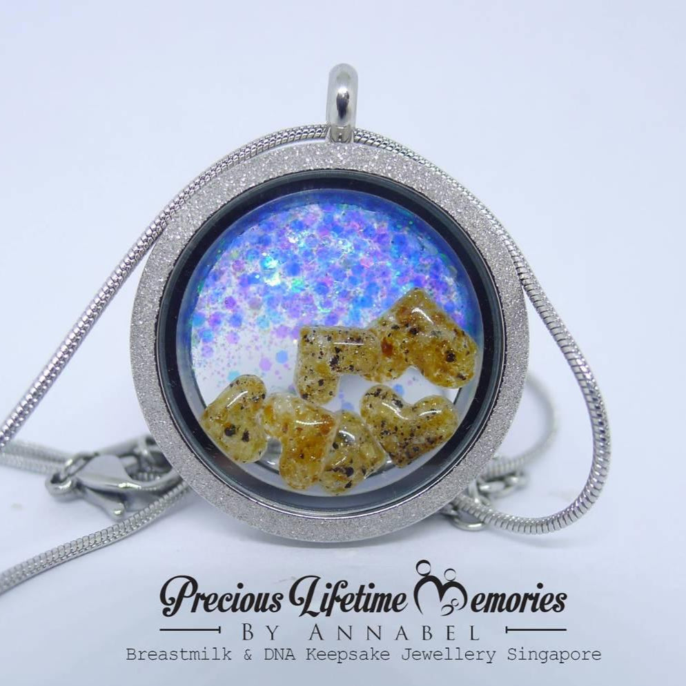 Necklace with a locket containing breastmilk and DNA, branded 'Precious Lifetime Memories by Annabel'.