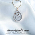 Teardrop-shaped pendant with heart designs on a white satin background, featuring 'Precious Lifetime Memories by Annabel'.