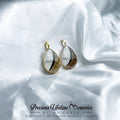 Teardrop-shaped earrings on a white fabric background with 'Precious Lifetime Memories by Annabel' branding.