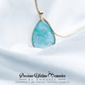 Teardrop-shaped turquoise pendant on a gold chain against a white fabric background with 'Precious Lifetime Memories by Annabel' branding.