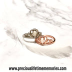 Two heart-shaped rings with crowns on a white feather background, featuring the brand 'preciouslifetimememories.com'.