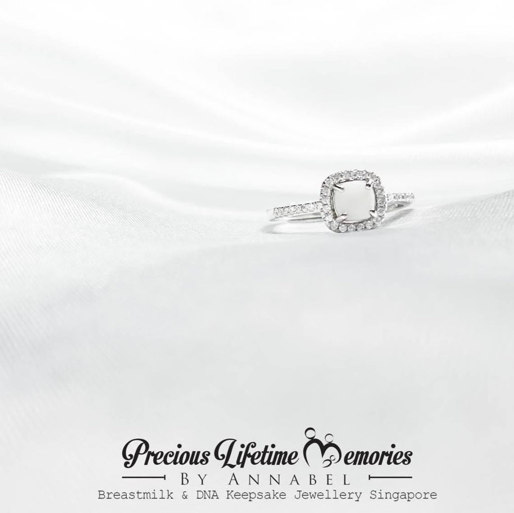 Silver ring with a diamond on a white satin background, featuring 'Precious Lifetime Memories by Annabel' branding.