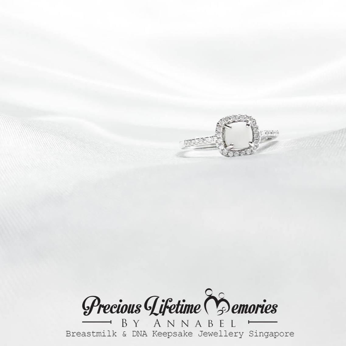 Silver ring with a diamond on a white satin background, featuring 'Precious Lifetime Memories by Annabel' branding.