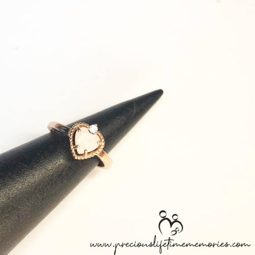 Heart-shaped ring on a black cone with 'precious lifetimes memories' branding.