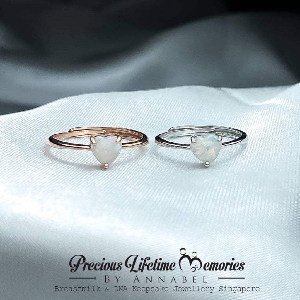 Two heart-shaped rings on a white fabric with 'Precious Lifetime Memories by Annabel' branding.