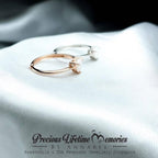 Gold hoop earrings on a white fabric with 'Precious Lifetime Memories by Annabel' branding.