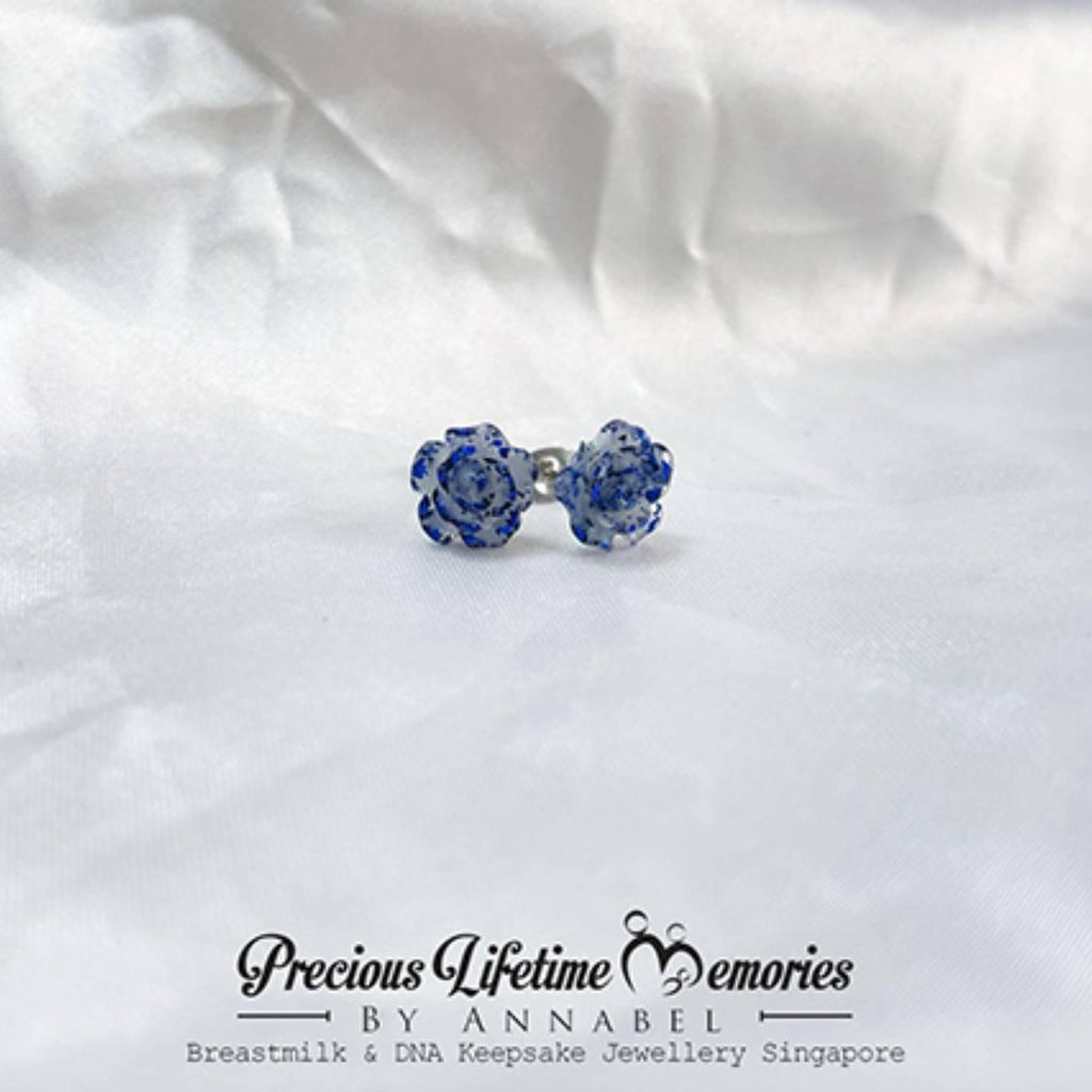 Blue bow-shaped earrings on a white fabric background with 'Precious Lifetime Memories by Annabel' branding.