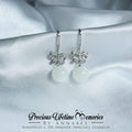 Silver earrings with white stones on a satin background, featuring 'Precious Lifetime Memories by Annabel' branding.