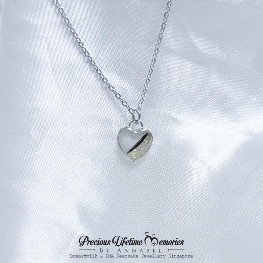 Heart-shaped necklace pendant on a white fabric background with 'Precious Lifetime Memories by Annabel' branding.