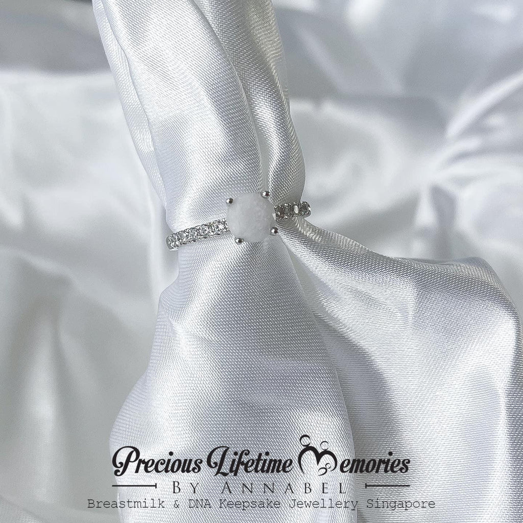 Silver necklace with a bow on white satin fabric, featuring 'Previous Lifetime Memories by Annabel'.