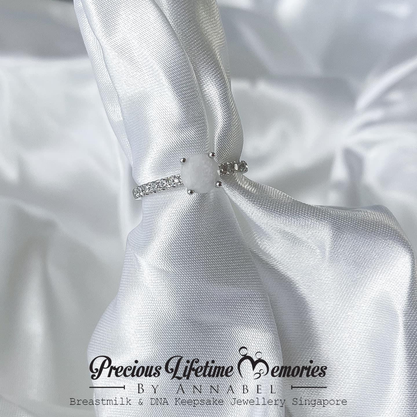 Silver necklace with a bow on white satin fabric, featuring 'Previous Lifetime Memories by Annabel'.