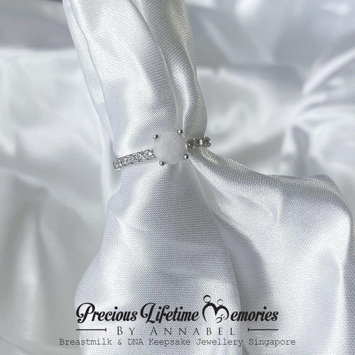 Silver necklace with a bow on white satin fabric, featuring 'Previous Lifetime Memories by Annabel'.