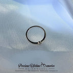 Silver ring with a small heart charm on a light blue fabric background, branded 'Precious Lifetime Memories by Annabel'.