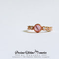Gold ring with a pink gemstone on a light gray background, featuring the brand 'Precious Lifetime Memories by Annabel'.