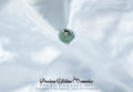 Turquoise charm on a white fabric background with 'Precious Lifetime Memories by Annabel' branding.