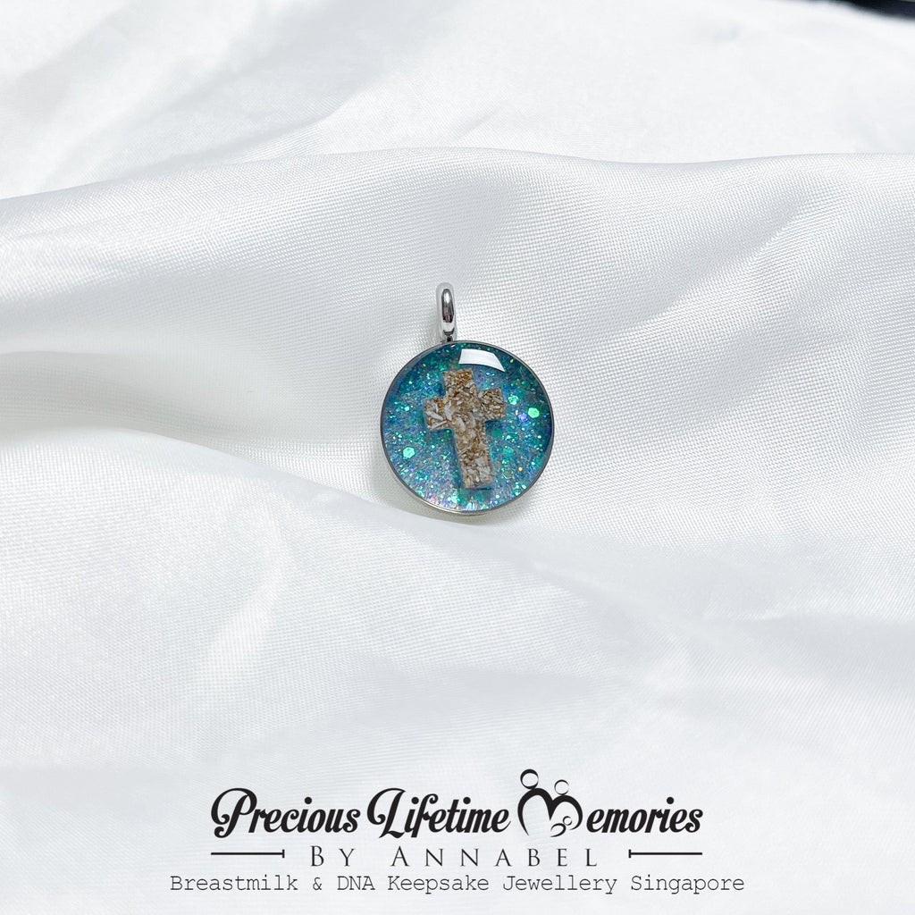 Pendant with a cross design on a white fabric background, featuring 'Precious Lifetime Memories by Annabel'.