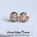 Round silver ashes earrings with embedded materials on a textured white background, branded 'Precious Lifetime Memories by Annabel'.