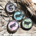 Four animal-themed necklaces on a wooden surface with 'precious lifetime memories.com' text.
