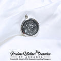 Silver locket with gray interior with cremation animal ashes, branded 'Precious Lifetime Memories by Annabel'.