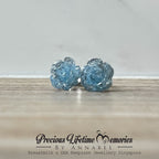 Pair of blue crystal stud earrings on a wooden surface with 'Precious Lifetime Memories by Annabel' branding.