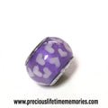 Purple charm with white heart patterns on a white background